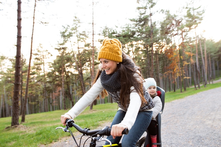 vrouw met kind achterop fiets in sfietszitje