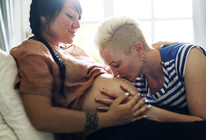 9 maanden zwanger lesbisch koppel partner kust zwangere buik