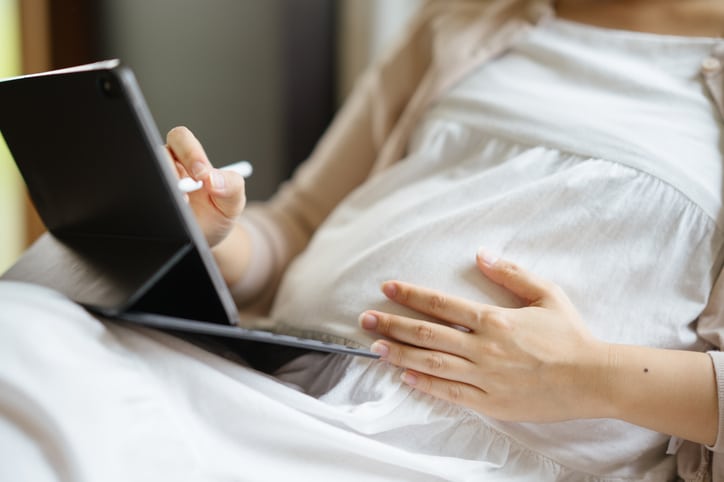 9 maanden zwanger zwangere vrouw met tablet