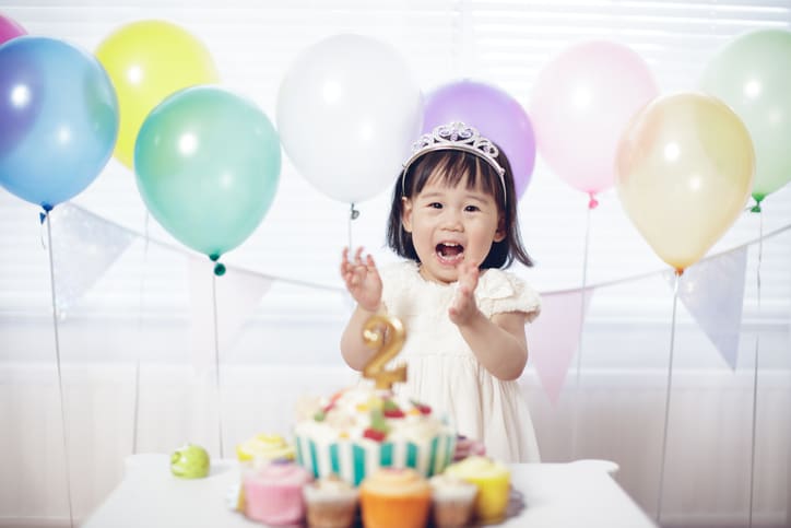 meisje viert tweede verjaardag met ballonnen en taart - baby 24 maanden