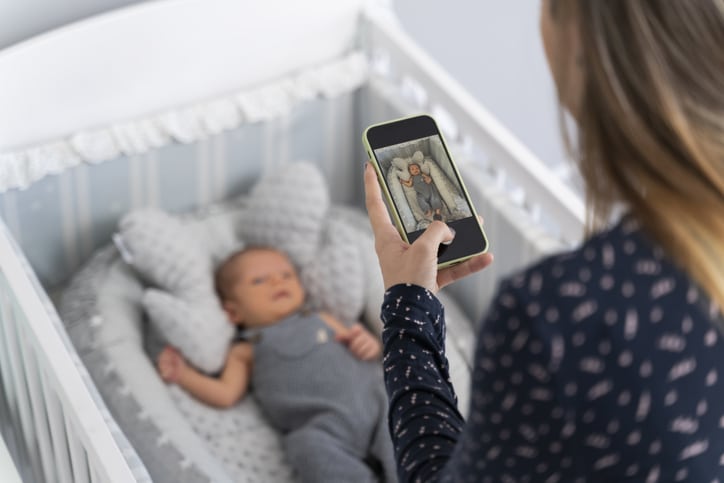 apps voor foto's bewerken - moeder maakt foto van baby in ledikant