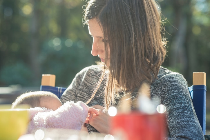 borstvoeding in het openbaar - jonge vrouw voedt haar baby