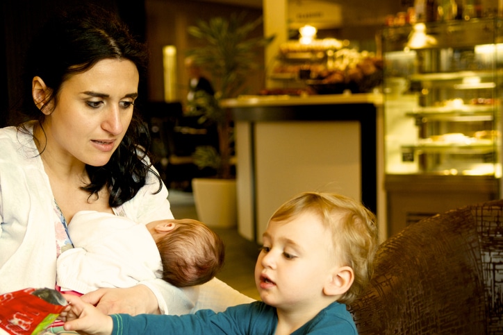 borstvoeding in het openbaar - moeder met peuter in cafe en baby aan de borst