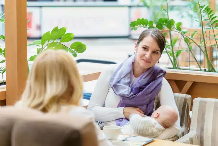 borstvoeding in het openbaar - vrouw voedt baby tegenover vriendin in cafe
