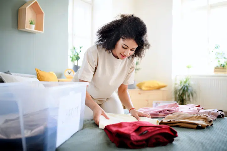tips voor opruimen vrouw ruimt woonkamer op