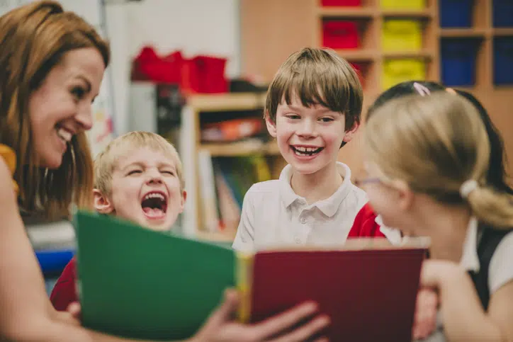 voorlezen belangrijk vrouw leest voor aan lachende kinderen
