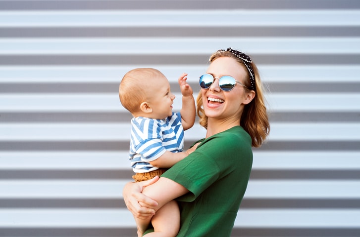 ontzwangeren jonge vrouw met zonnebril en baby
