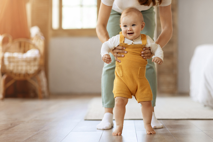 beweging stimuleren bij een baby - baby staat aan de hand van ouder