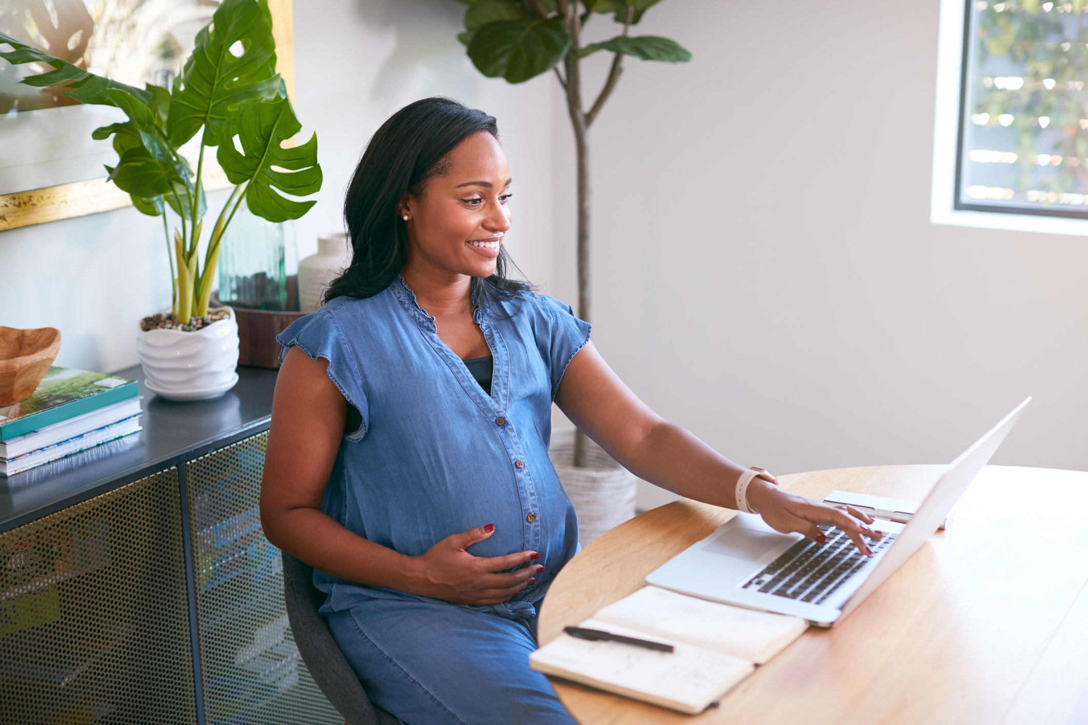 tips voor je zwangerschapsverlof - lachende zwangere vrouw achter laptop