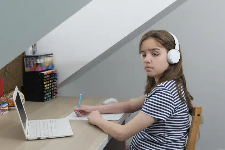 kind alleen thuis laten - meisje maakt huiswerk aan bureau