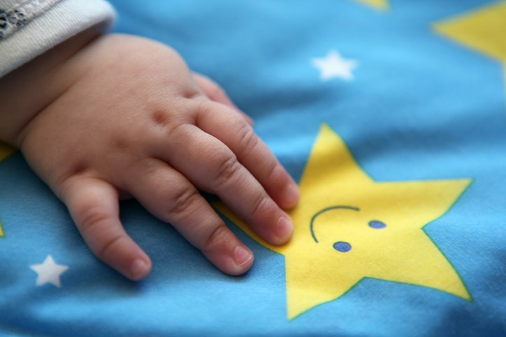 sterrenbeeld ram - babyhandje op laken met ster