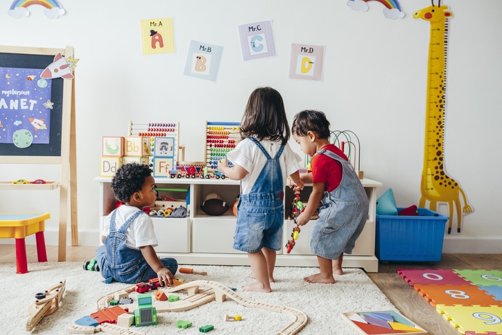 drie kinderen spelen met speelgoed in speelgoedkamer