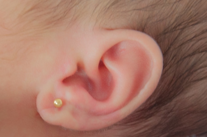 oorbellen schieten bij een baby - oor van pasgeboren baby met oorbel