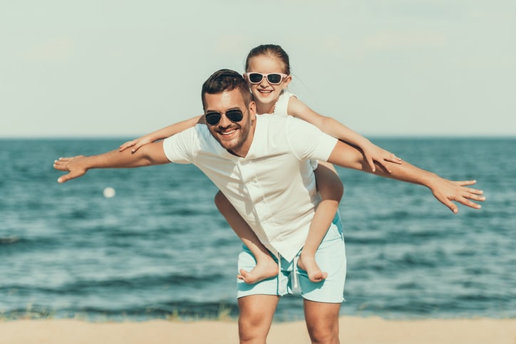 leukste stranden - vader met dochter op zijn rug op het strand