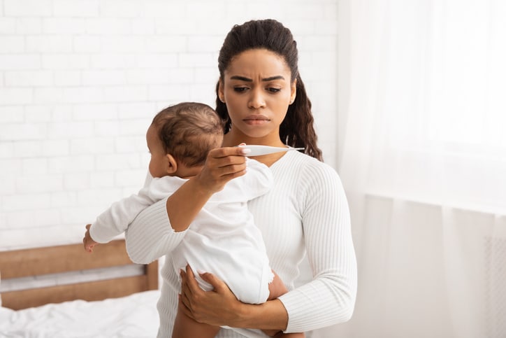 moeder met baby kijkt op thermometer - luchtweginfectie