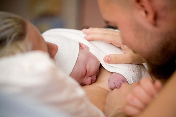 pasgeboren baby met vader en moeder - vaginale kunstbevalling
