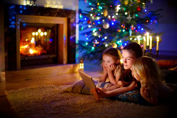 moeder met kinderen bij kerstboom kijken een filmpjekerstfilms-voor-kinderen-op-netflix 