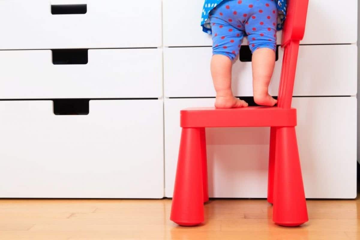 checklist voor het kindveilig maken van je huis - kindje op een stoel bij een kast