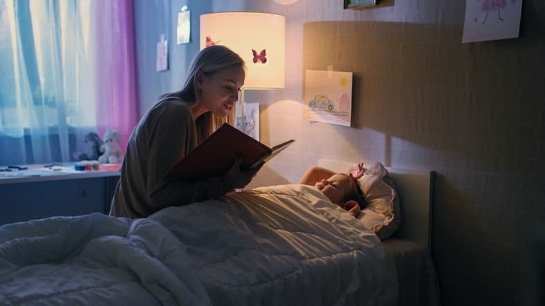 oude slaapritme na de vakantie - moeder-leest-meisje-verhaaltje-voor-voor-het-slapen