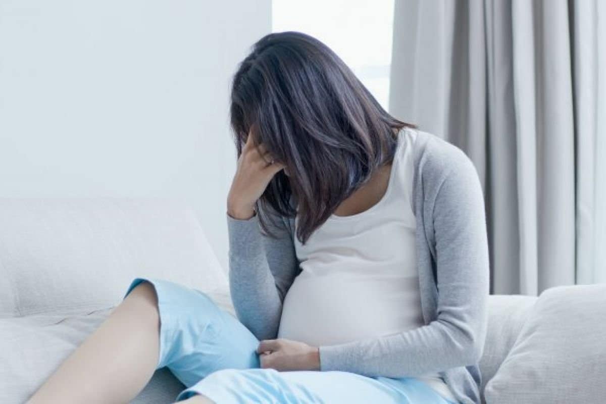 vrouw met hyperemesis gravidarum - zwangere vrouw op de bank