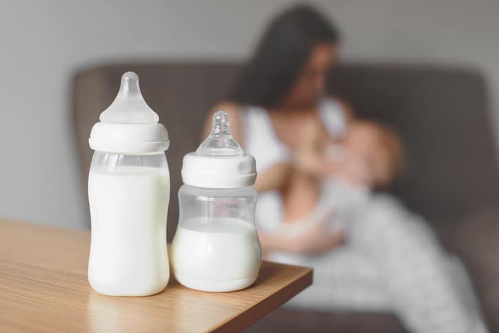 flesjes met gekolfde melk en moeder met baby - enkelzijdige of dubbelzijdige kolf