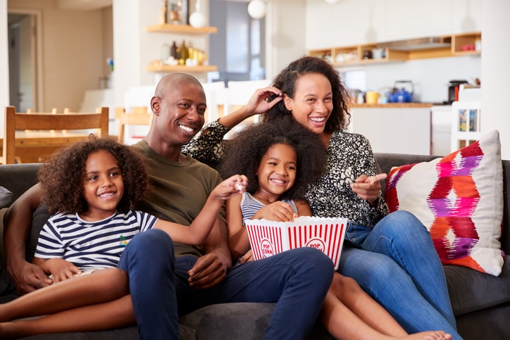 familiefilms op netflix - gezin op de bank met popcorn