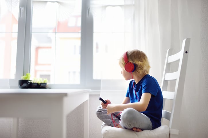 luisterboeken voor kinderen kind met koptelefoon kijkt uit het raam