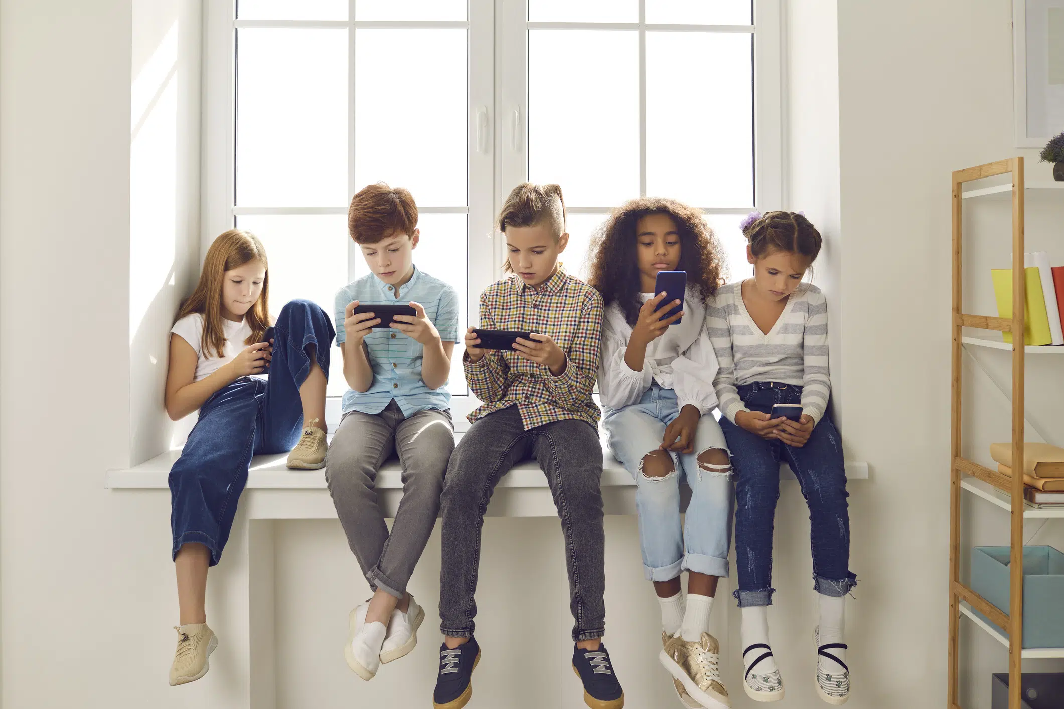 abonnement voor je kind - kinderen met smartphone in de vensterbank