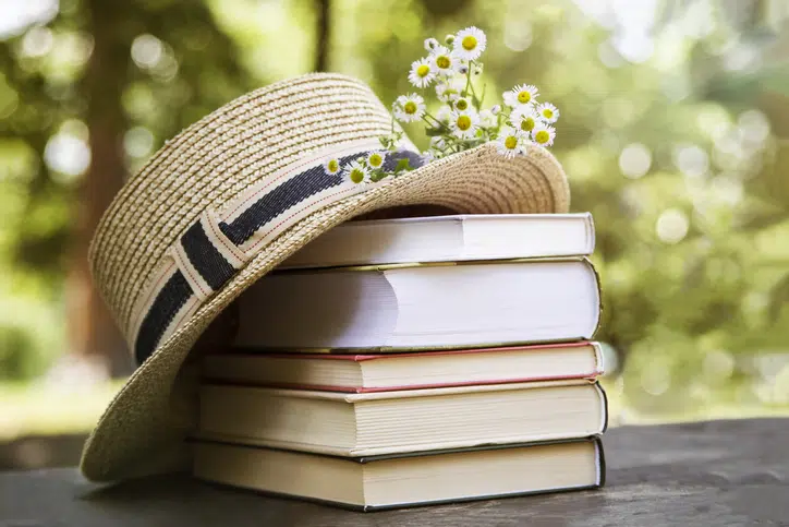 Routine op vakantie zo kom je zelf ook uitgerust terug - stapel boeken en zomerhoedje
