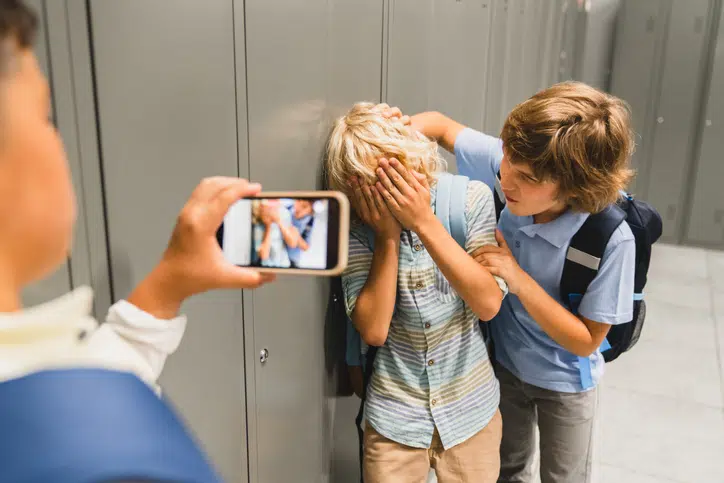als je kind een pester is - jongen pest een jongen ander kind filmt met smartphone