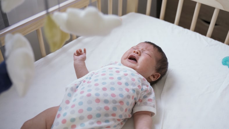 slaapregressie baby - huilende baby in ledikant