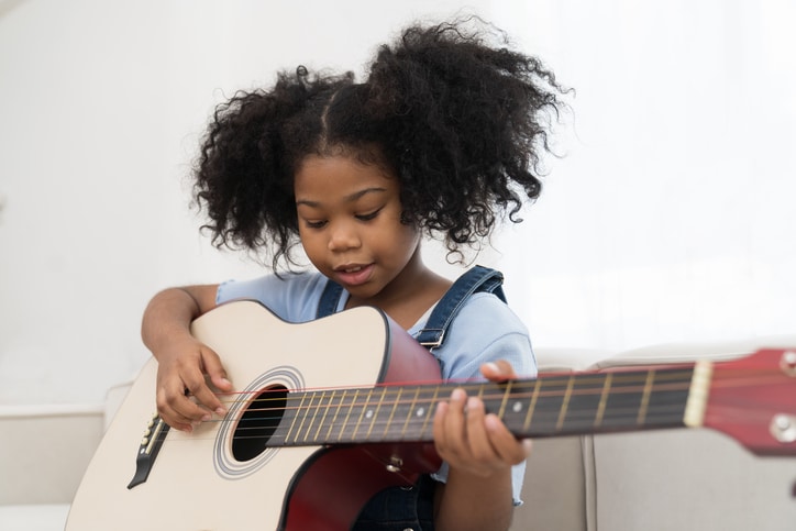 educatief speelgoed voor een 8-jarige - meisje speelt gitaar