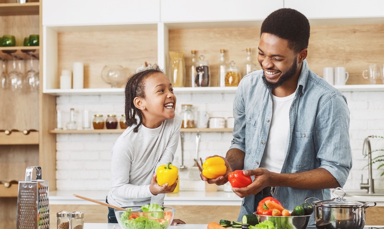 kind meer groente laten eten - vader en kind maken plezier in de keuken