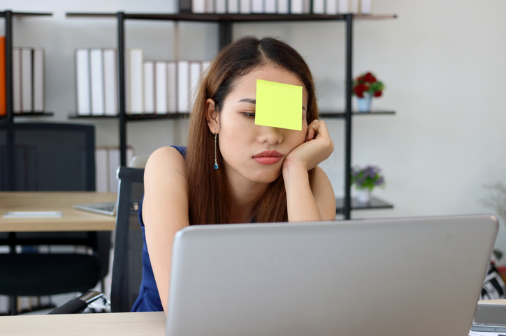 mental load - vrouw achter laptop met post it op voorhoofd