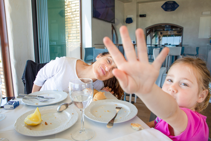 moeder en dochter aan tafel, vader maakt foto