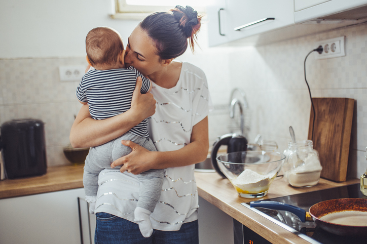 Moeder knuffelt met baby in de keuken
