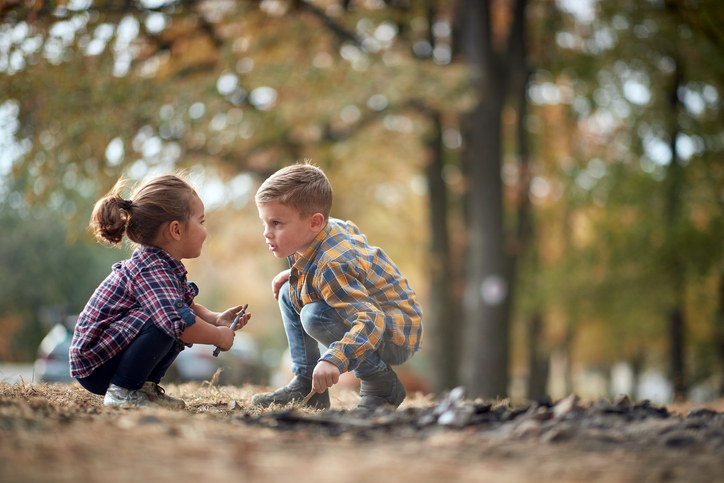 Twee kinderen spelen in het bos