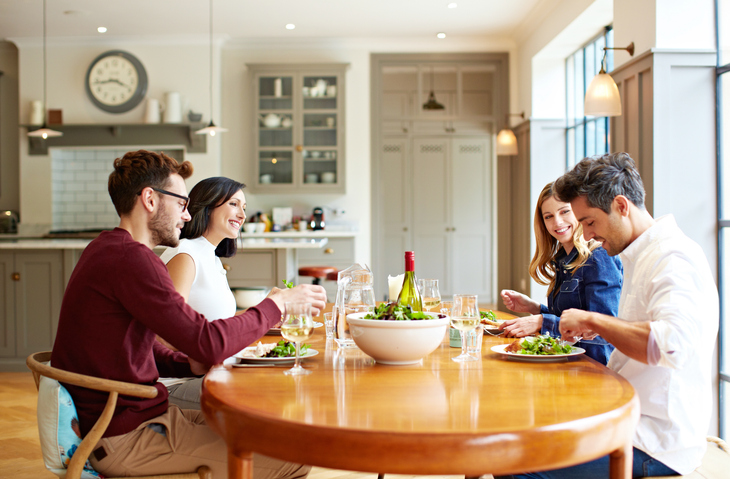 Aan een ovale eettafel wordt van alles gedaan behalve eten