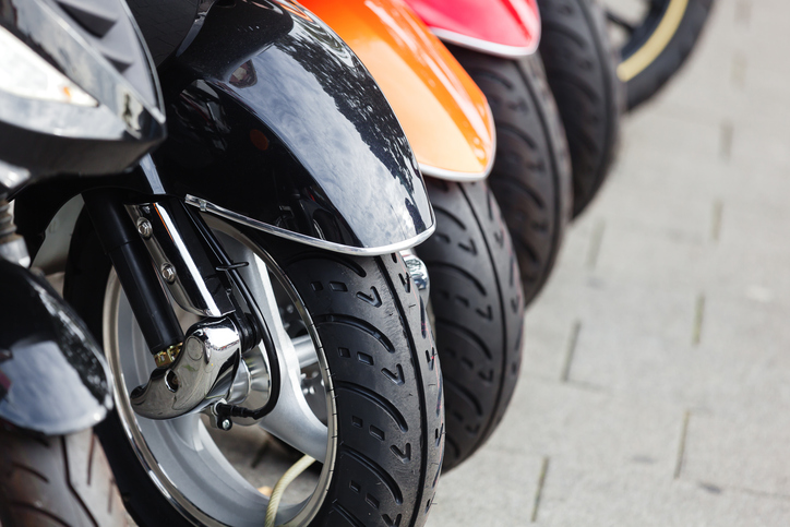Close-up van wielen van een rij geparkeerde scooters