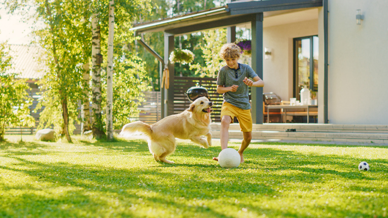 Jongen aan het voetballen in de tuin